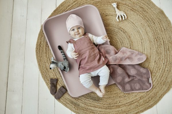 Pink changing mat on floor with baby