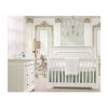 White and gold baby room with white classic double dresser and crib with detailed moldings